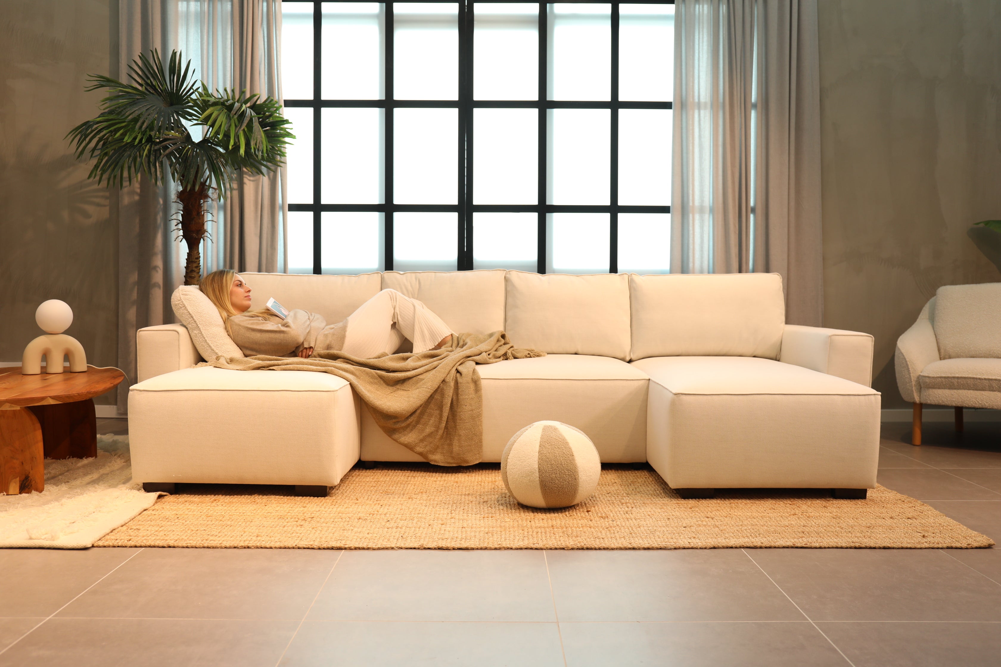 Mulher relaxada no sofá Budwing - Centro de ajuda e FAQ sobre colchões e sofás